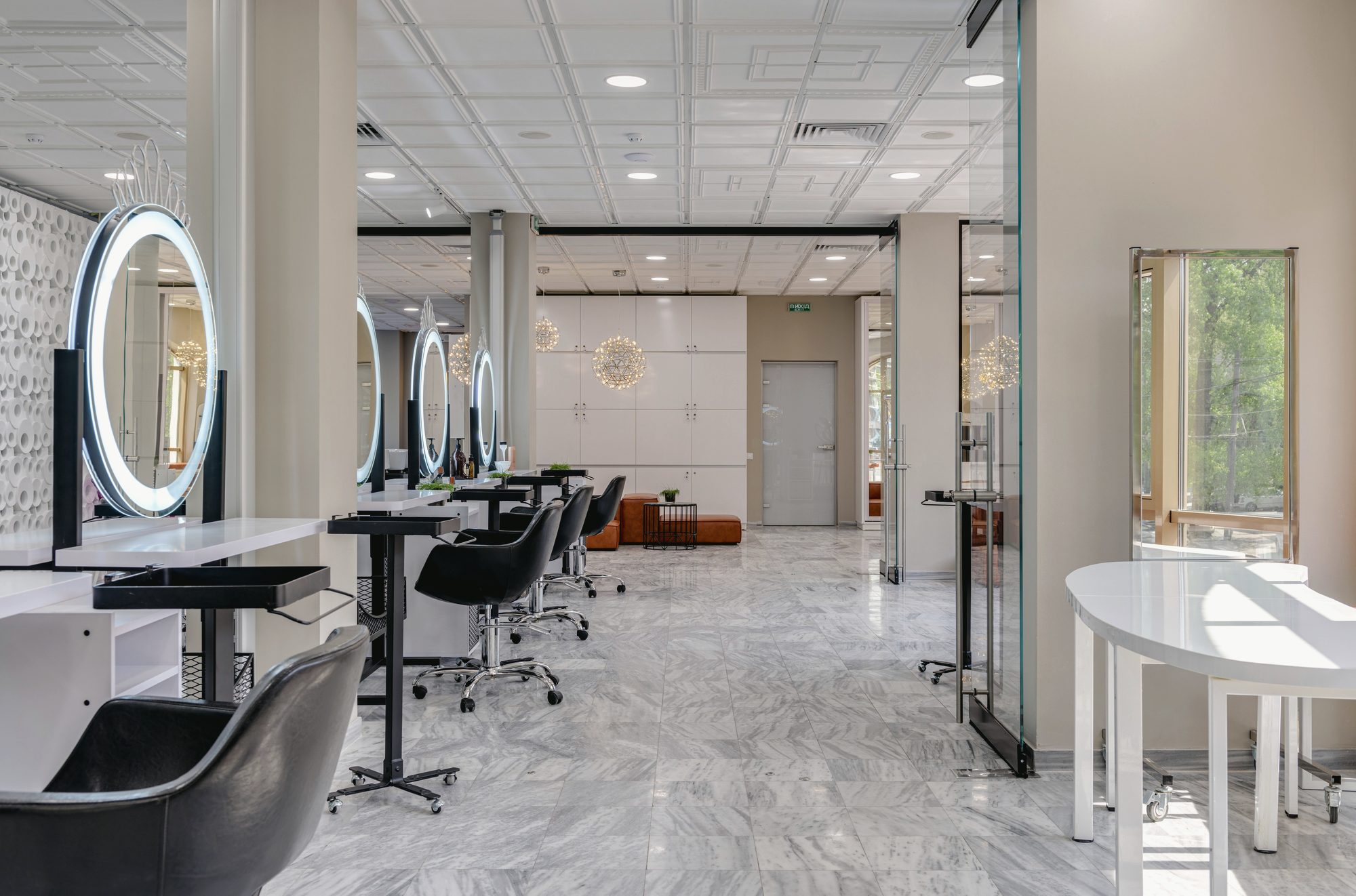 A row of mirrored stations running back along the studio's bright north wall.